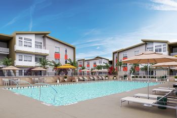 A swimming pool in front of apartment buildings with sun loungers and umbrellas.